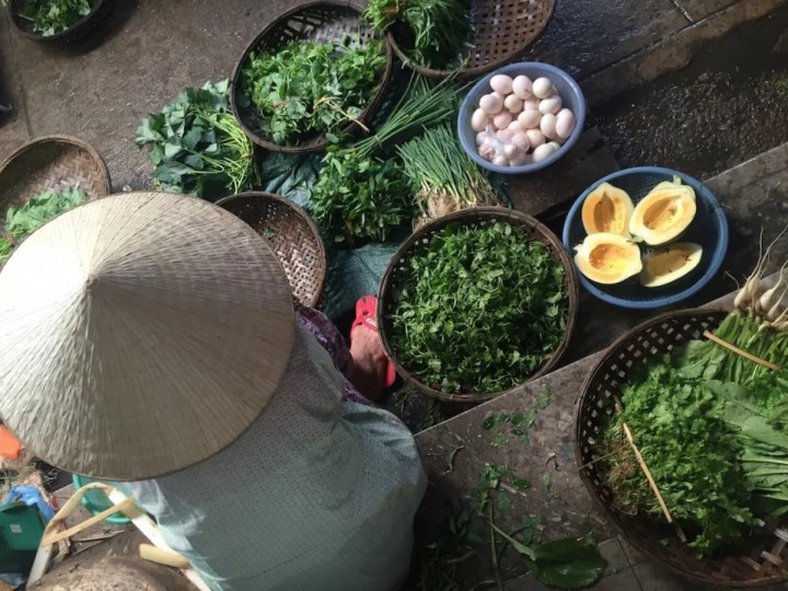 kvinde der sælger grøntsager på marked